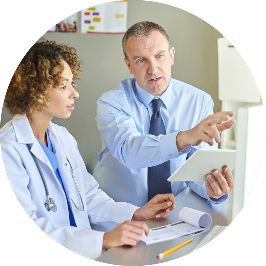 Two healthcare workers collaborating around a medical device.
