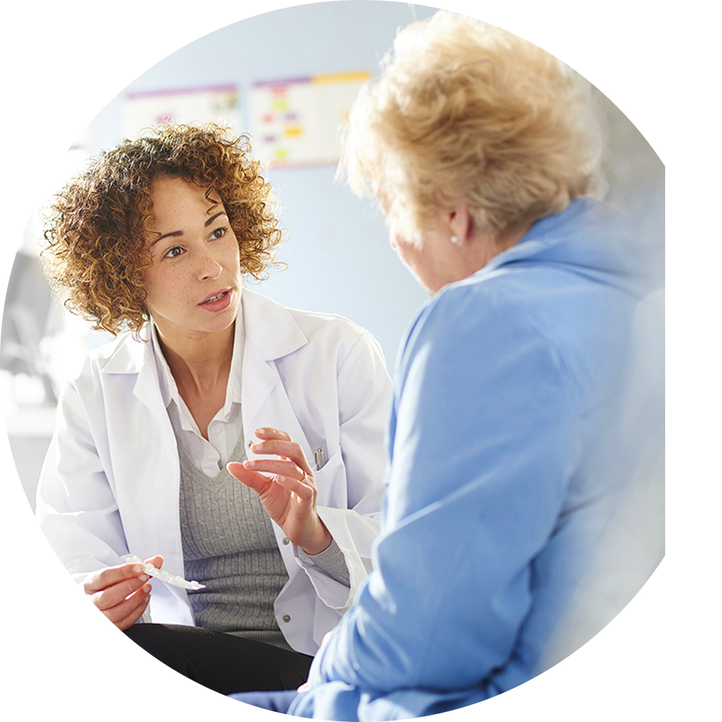 Doctor in white lab coat speaking with an older patient.