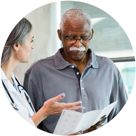 Doctor in white lab coat holding a piece of paper and explaining results to a patient