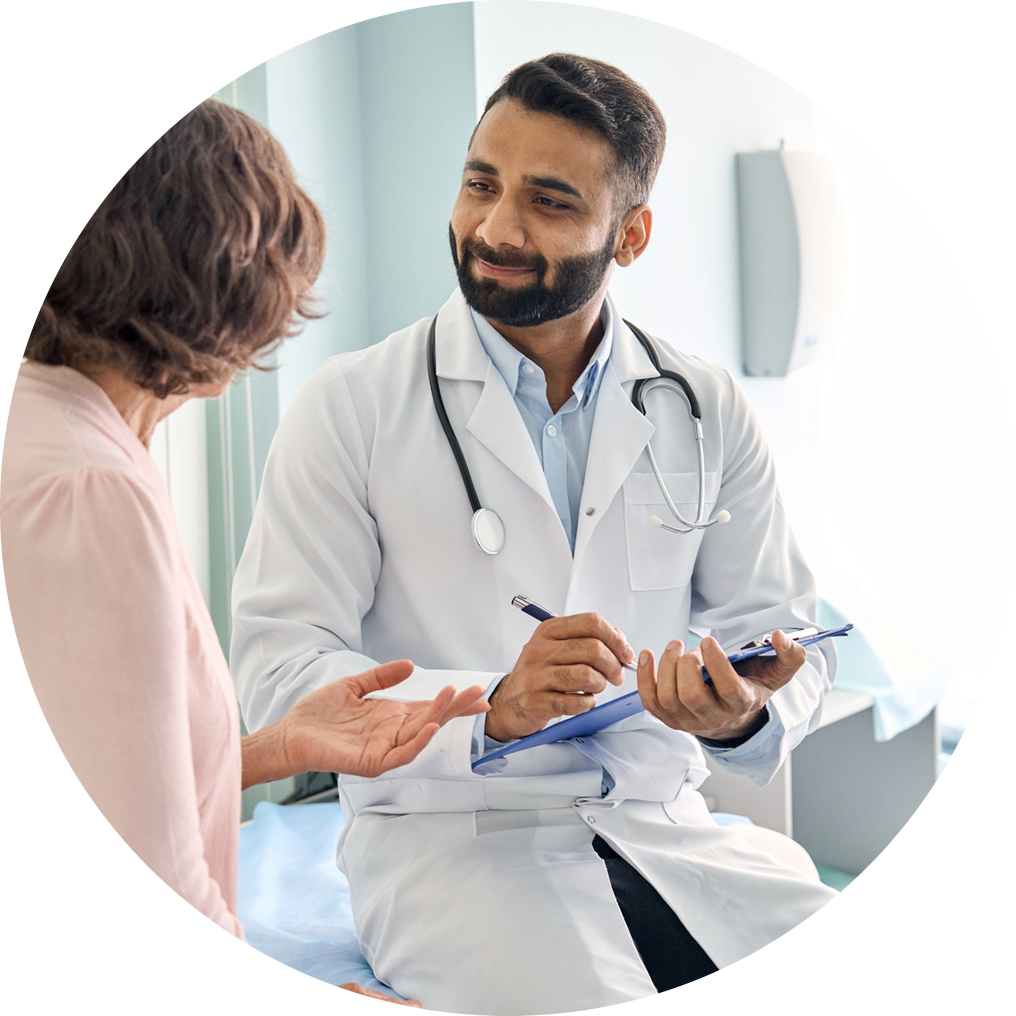 Smiling doctor in white lab coat looks at patient