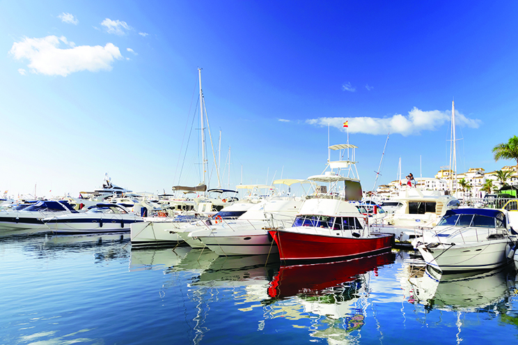 marina on water with boats and blue skies