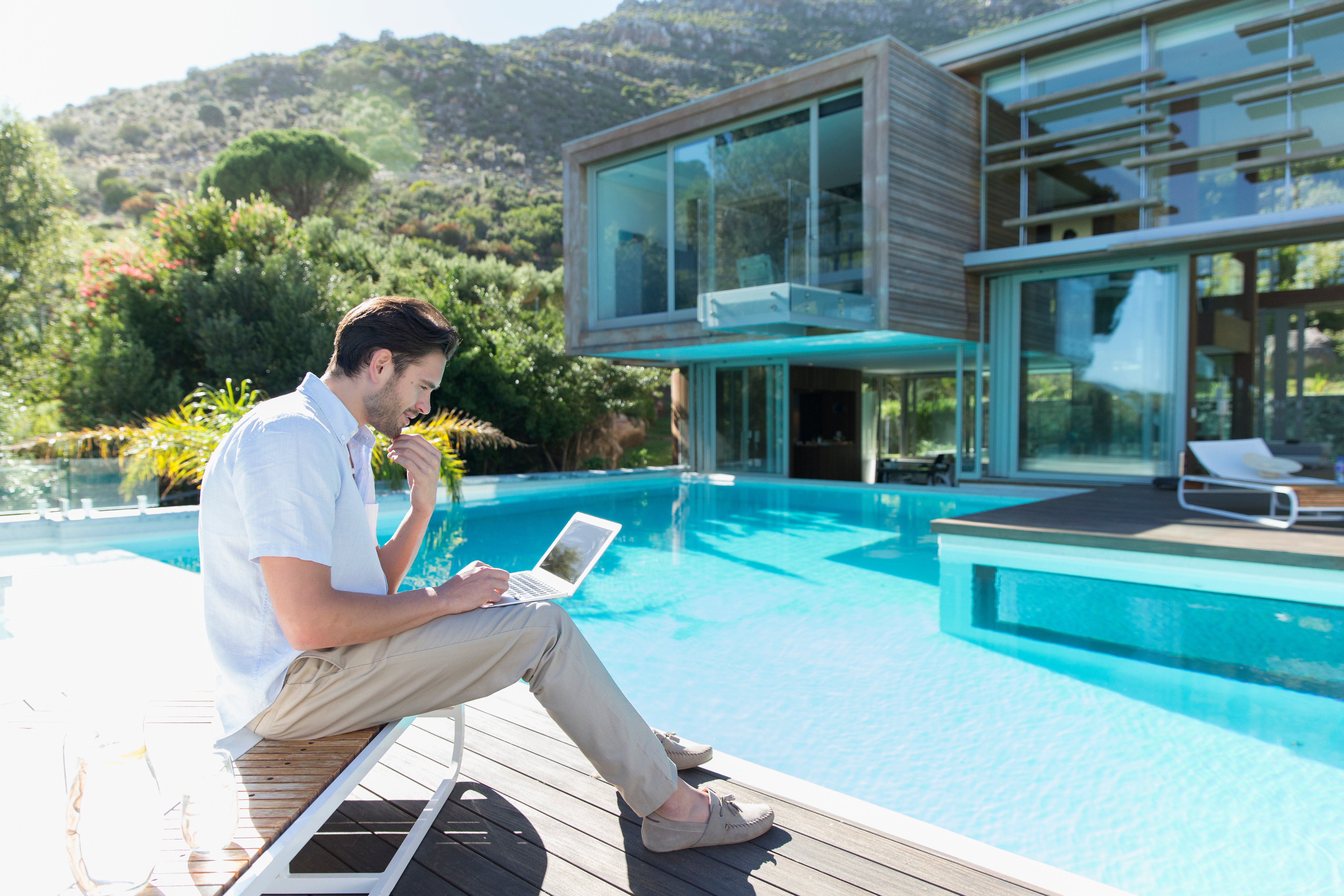Man with a laptop by the pool