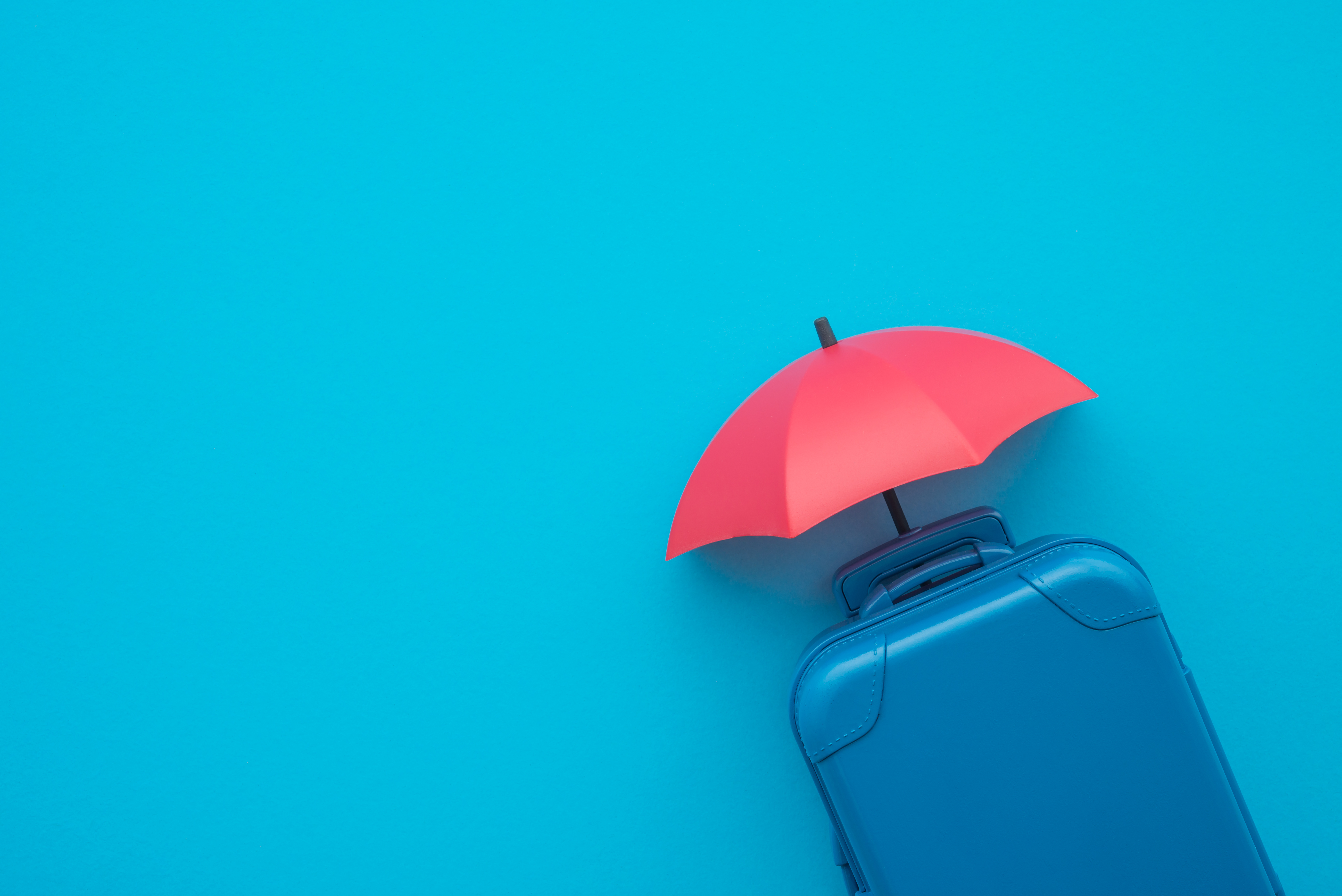 Suitcase with red umbrella