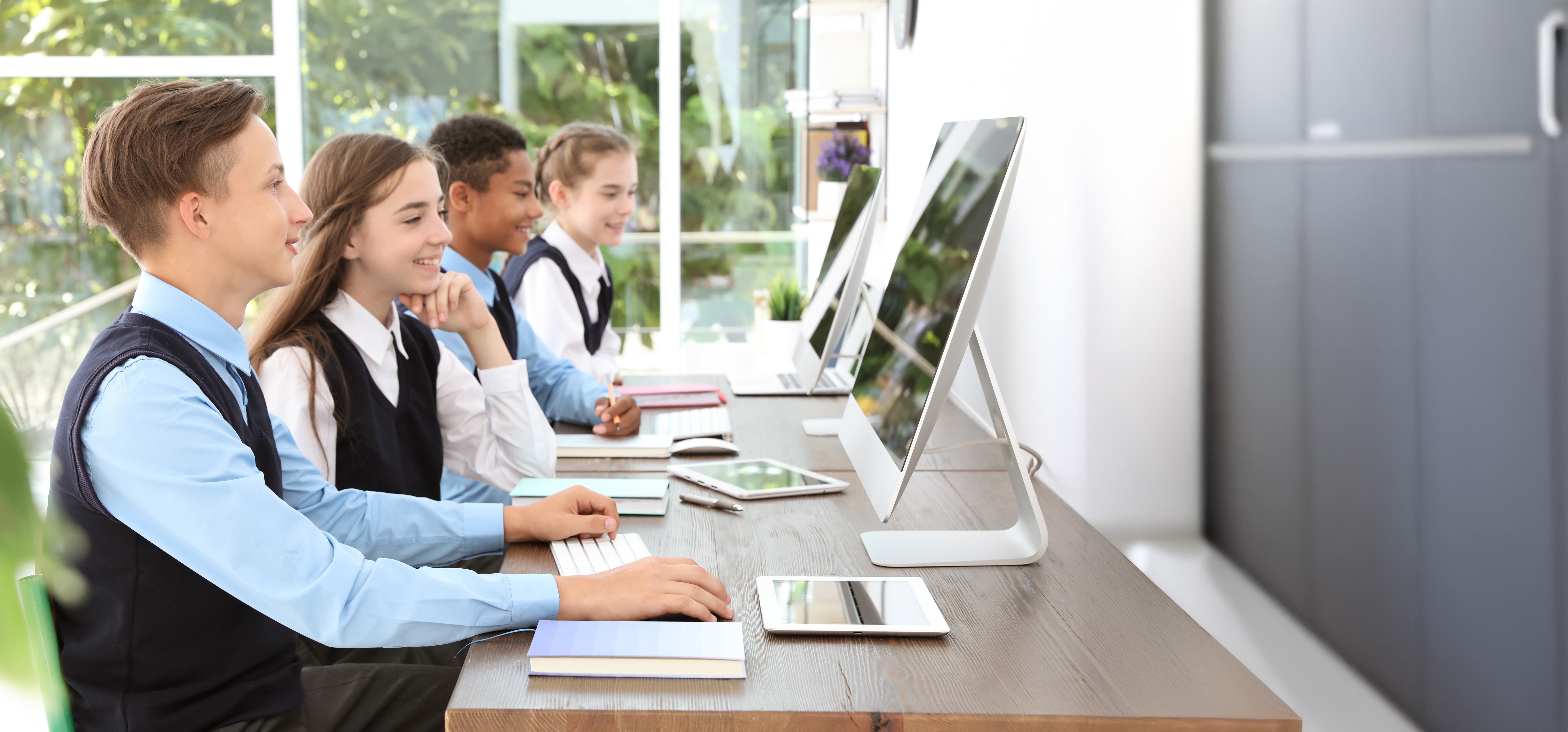 uniformed students in front of computers