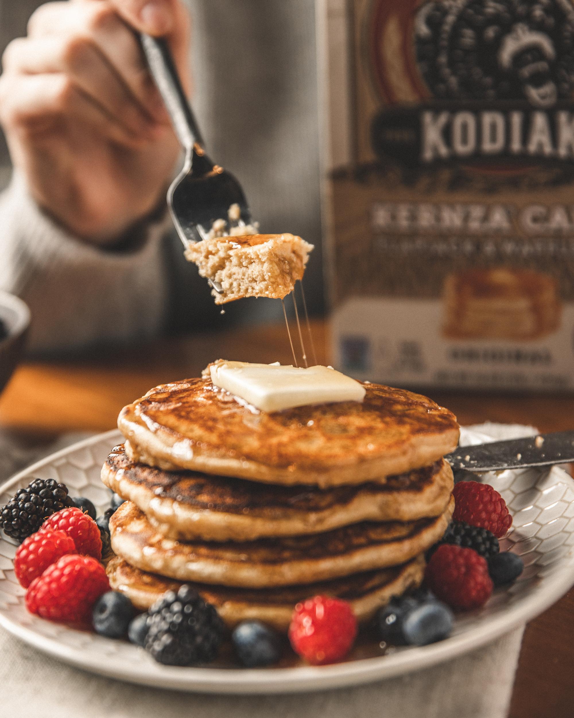 A delicious stack of Kodiak Cakes Kernza Cakes surrounded by berries