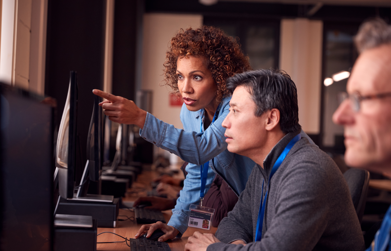 Two businesspeople reviewing something on a monitor