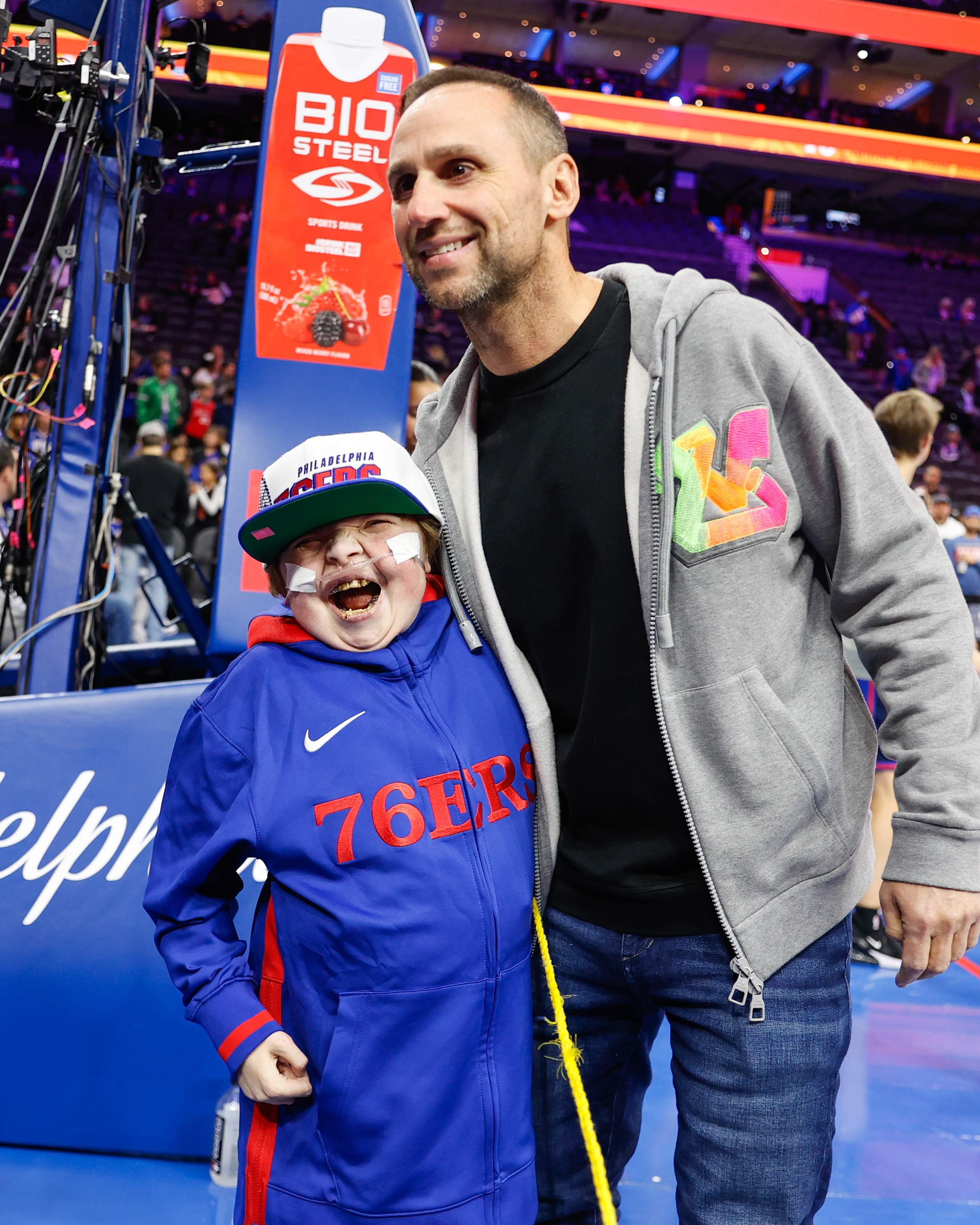 Michael Rubin, Founder & CEO of Fanatics, standing with Make-A-Wish alumni Beau.