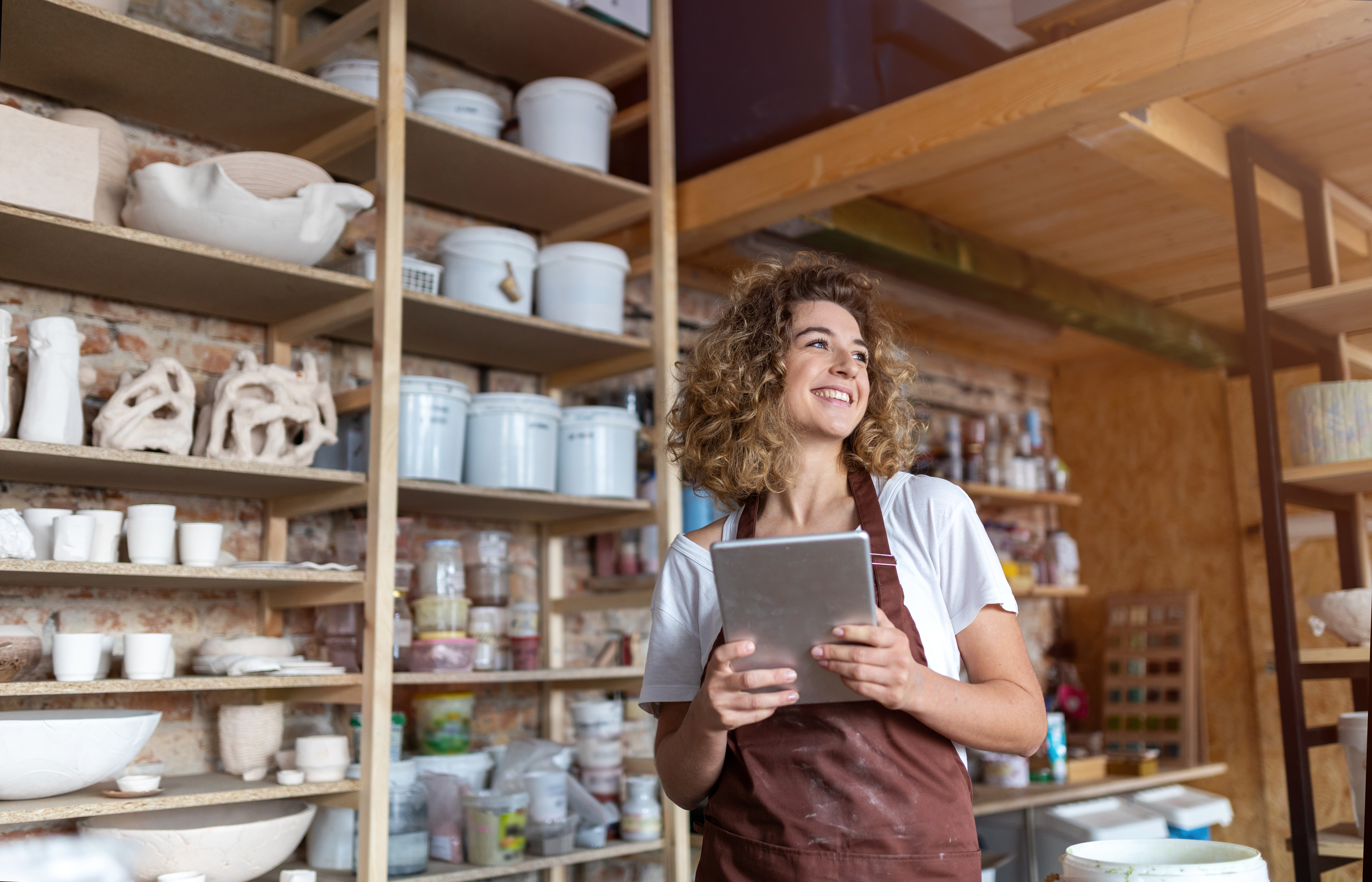 Small business owner in front of shelves

