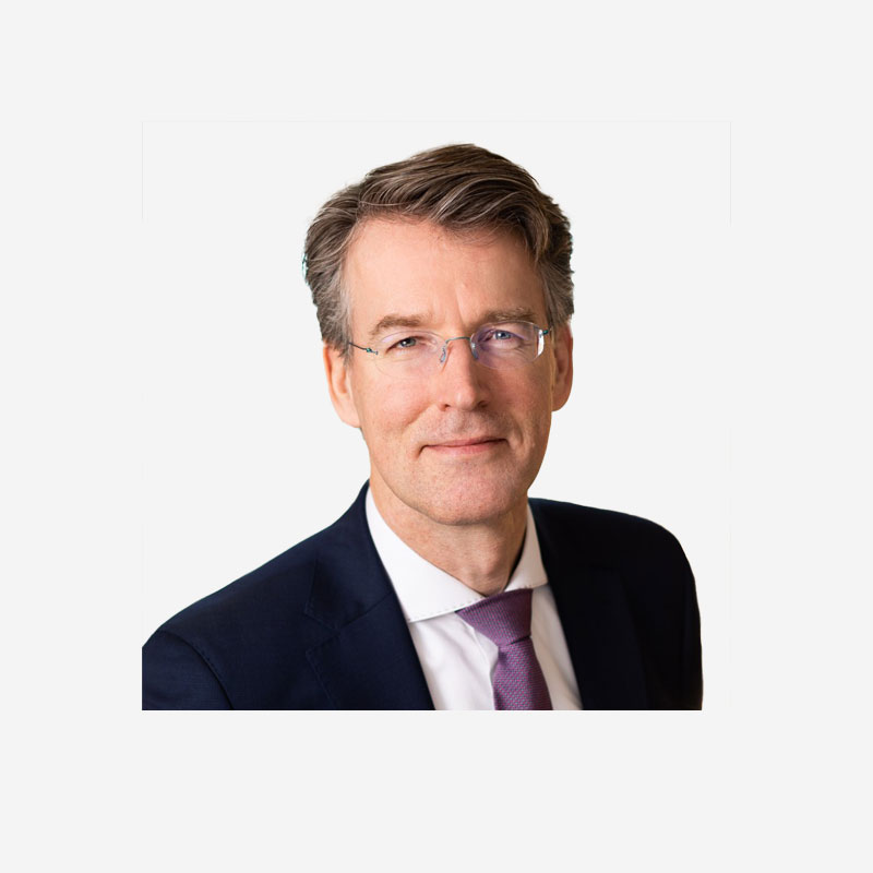 Portrait of mature businessman. Male executive is wearing T-shirt. Professional is smiling against gray background. Confident businessman with arms crossed. Mature mixed race man smiling
