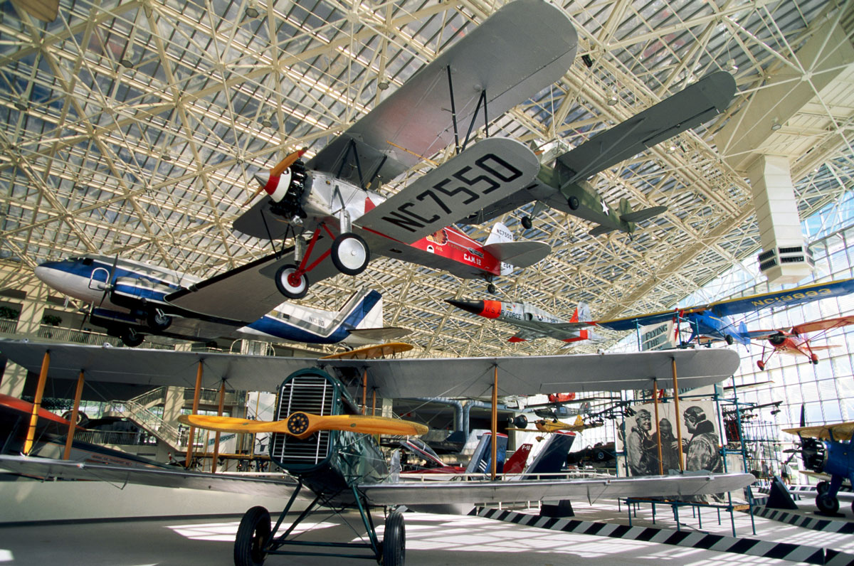 Historical planes hanging from the ceiling in a large hangar museum