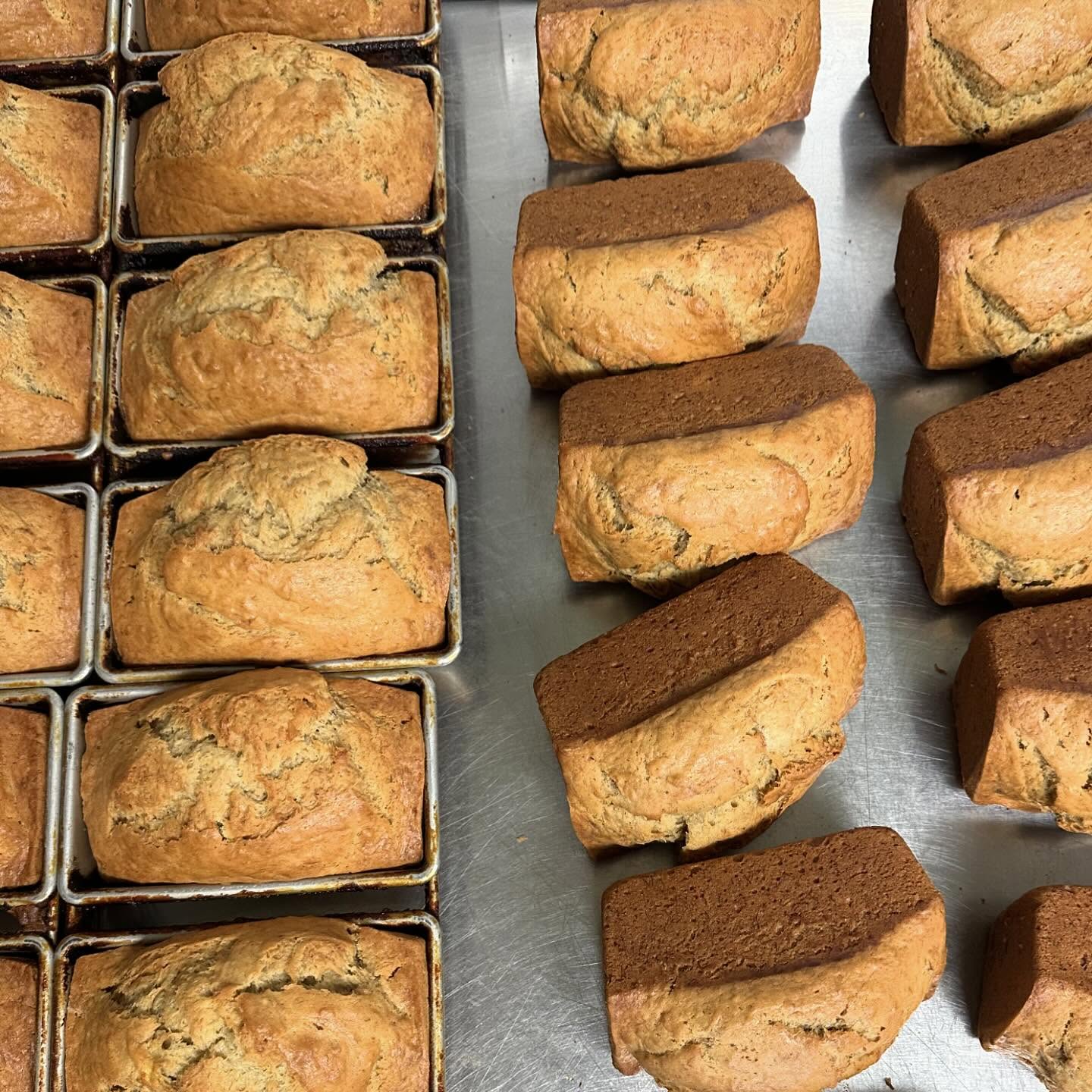 Four rows of small banana bread loaves on a stainless steel tabletop