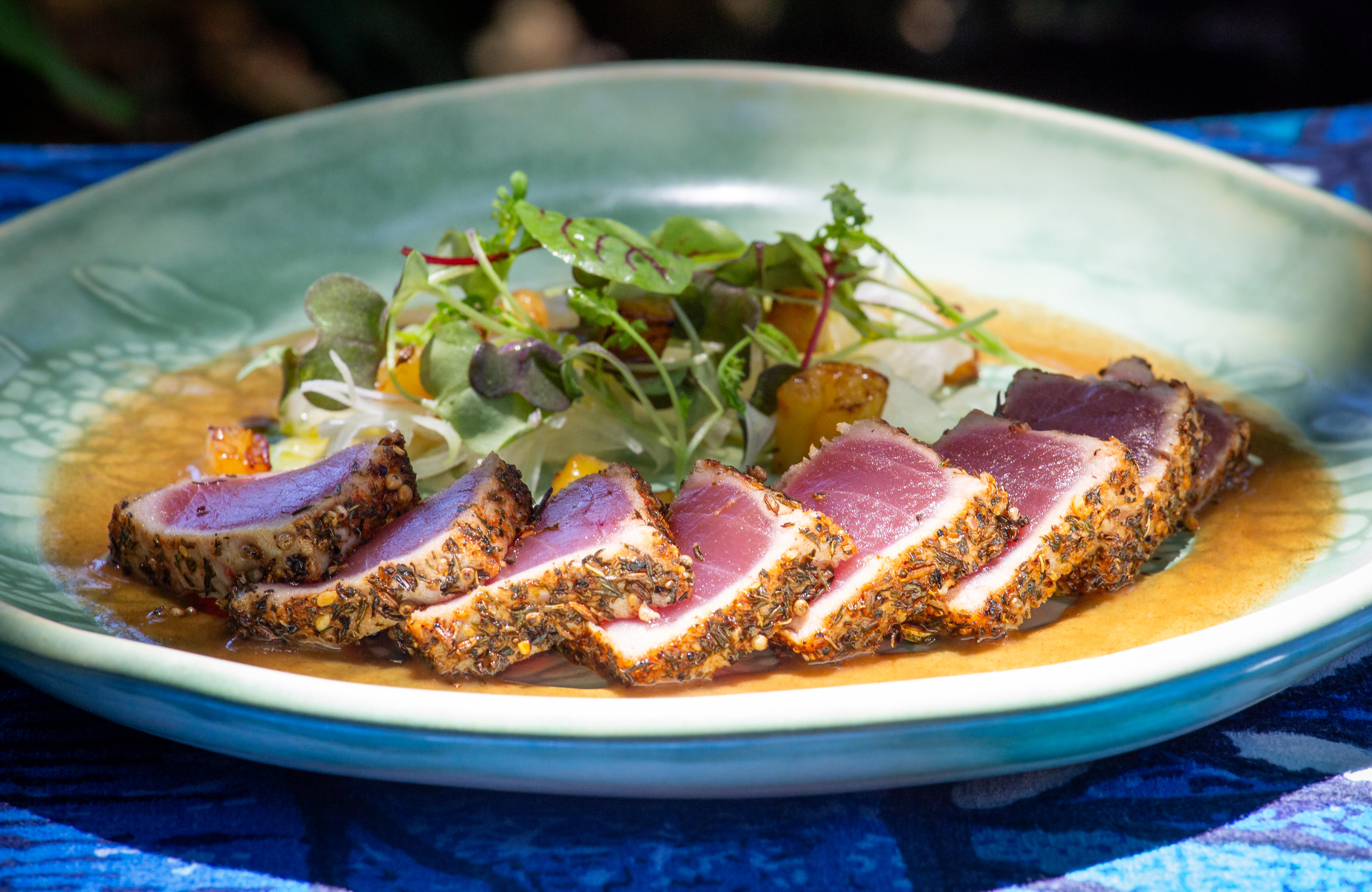 Plate of sliced fish, stacked in a row with garnish on the side