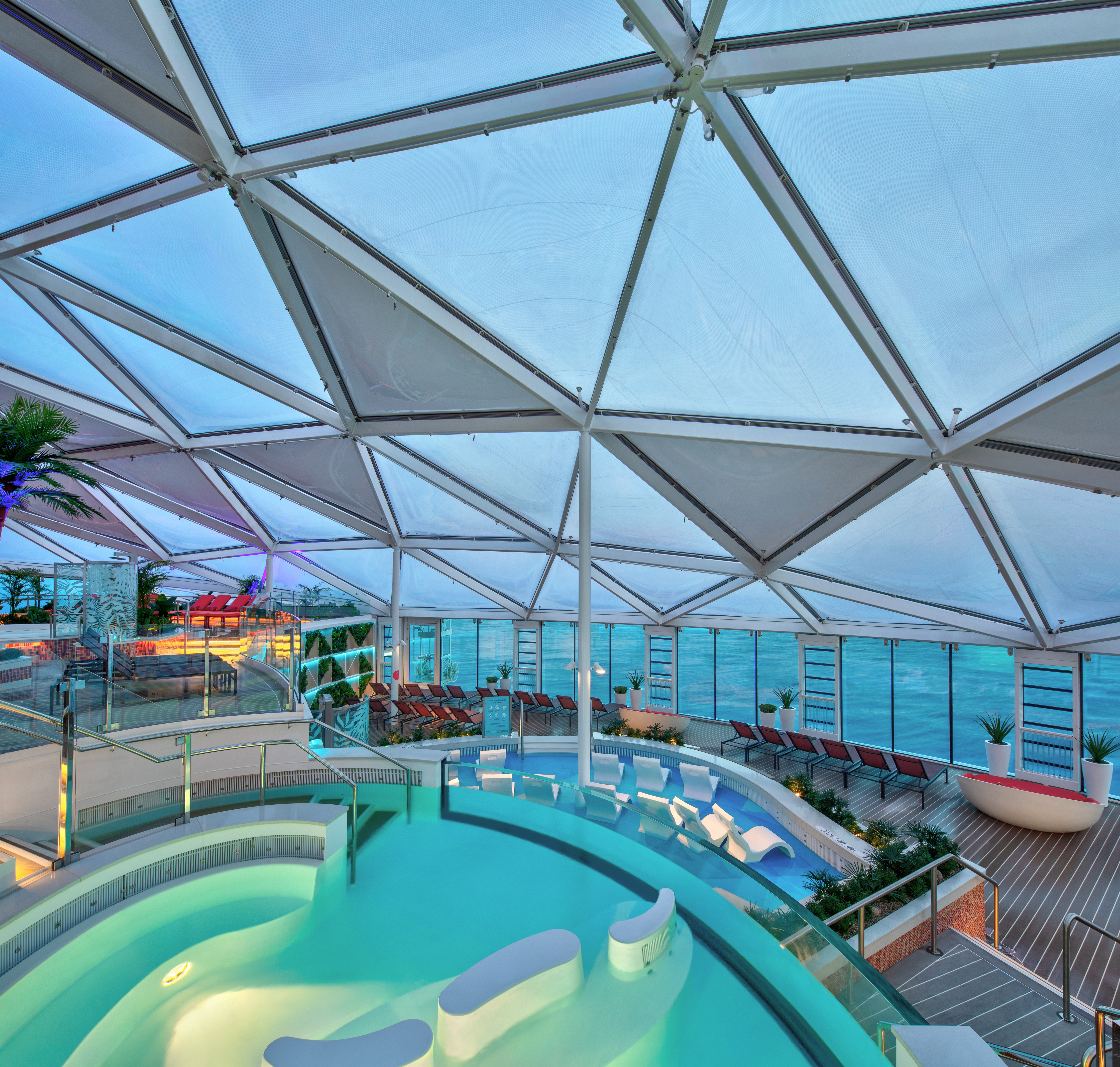 Circular pool beneath a dome of glass on the top level of a cruise ship
