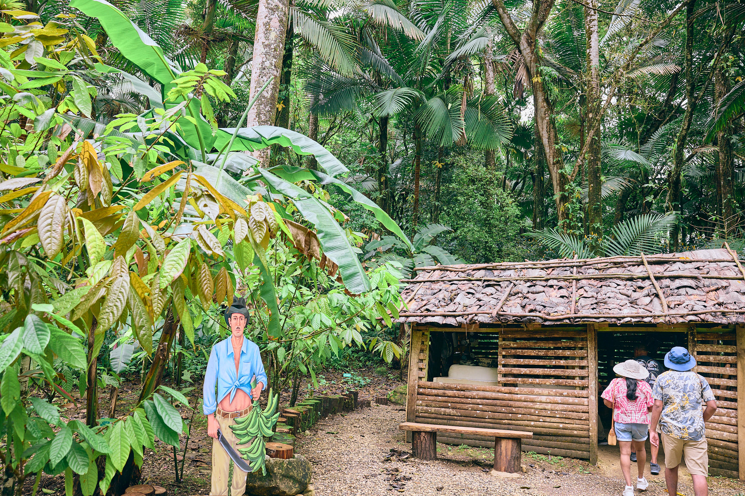 Family walking in the doors of historical, hand-built cabin in a jungle