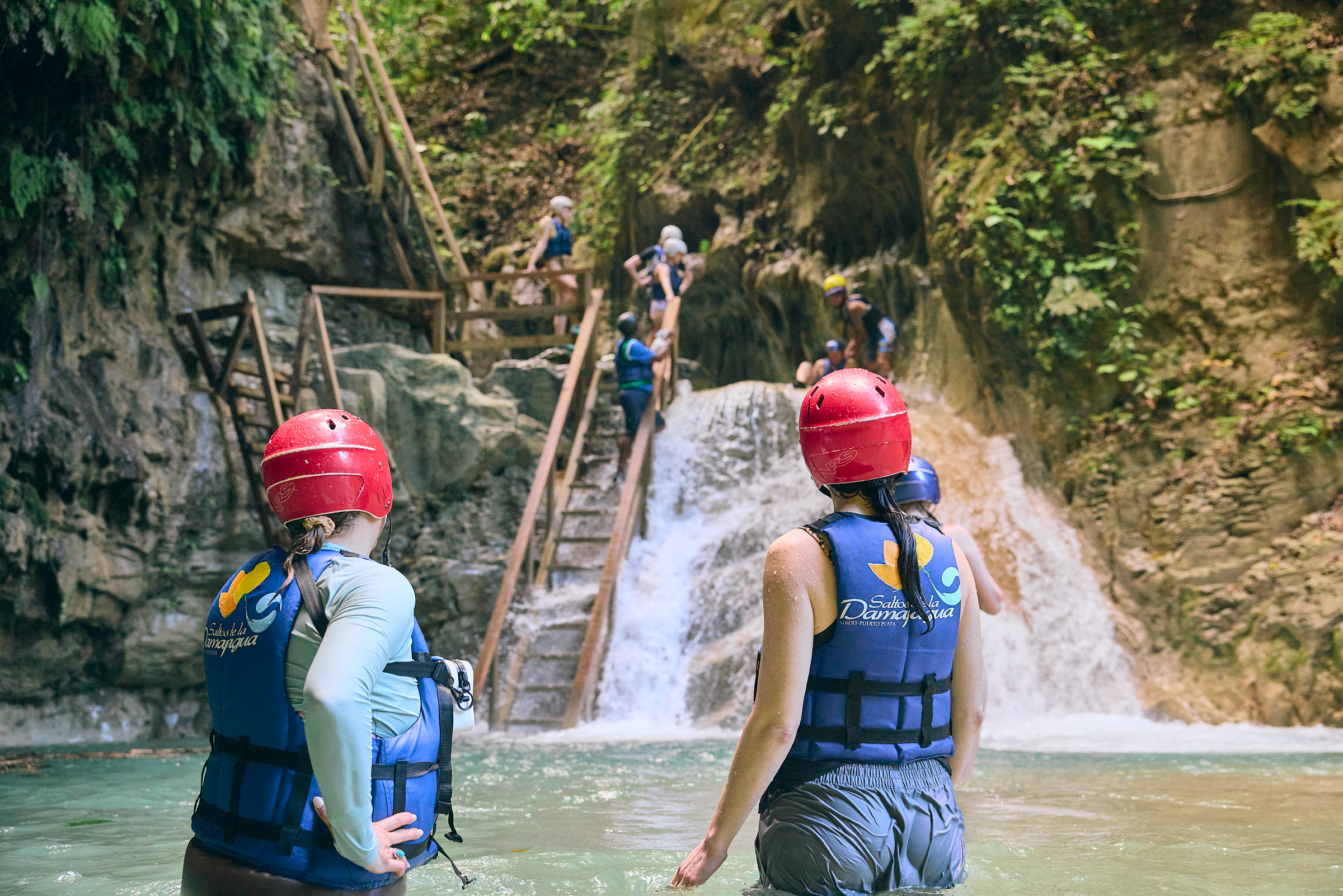Two women looking up at a waterfall