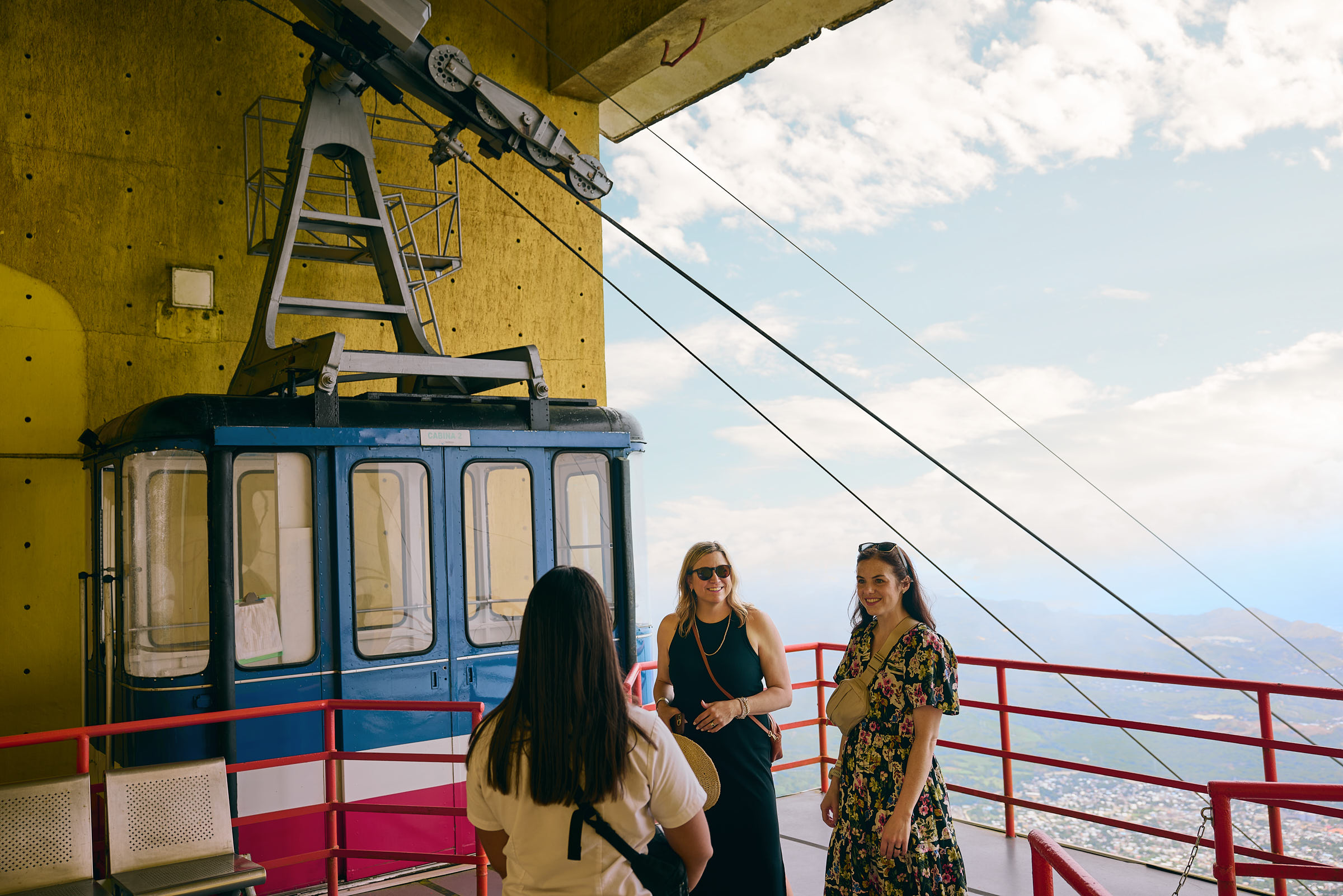 Three women talking together at the top of a cable car platform