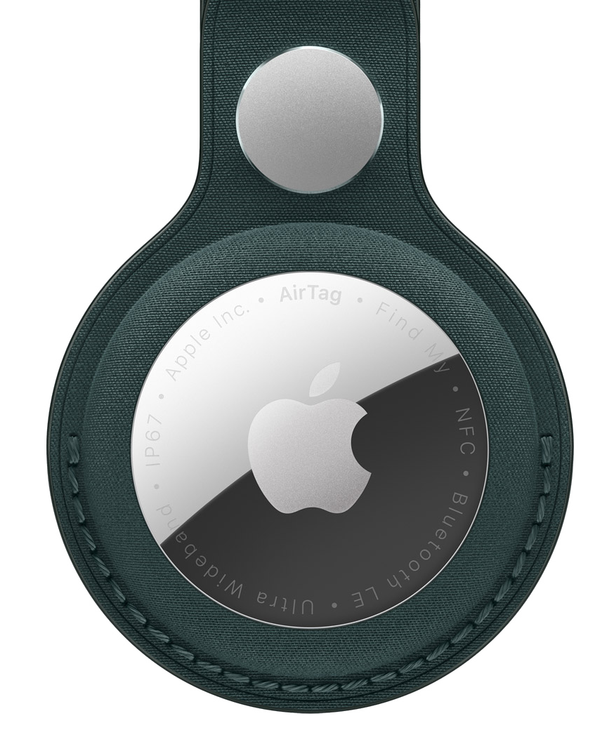Small metal disk with the Apple logo on it, inside a dark green leather case