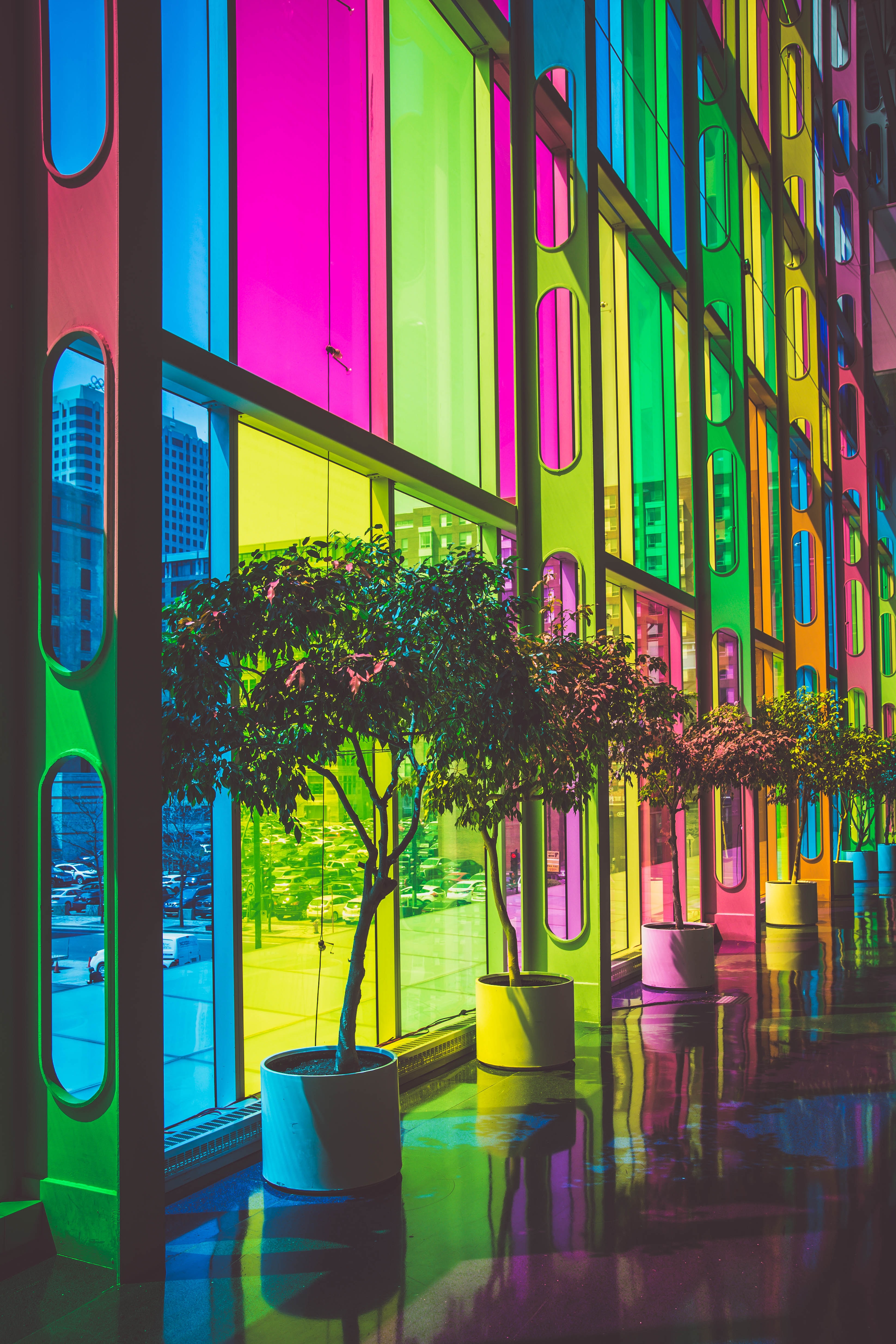 Neon brightly colored windows in vibrant blue, pink, green, and yellow. Geometric abstract design.