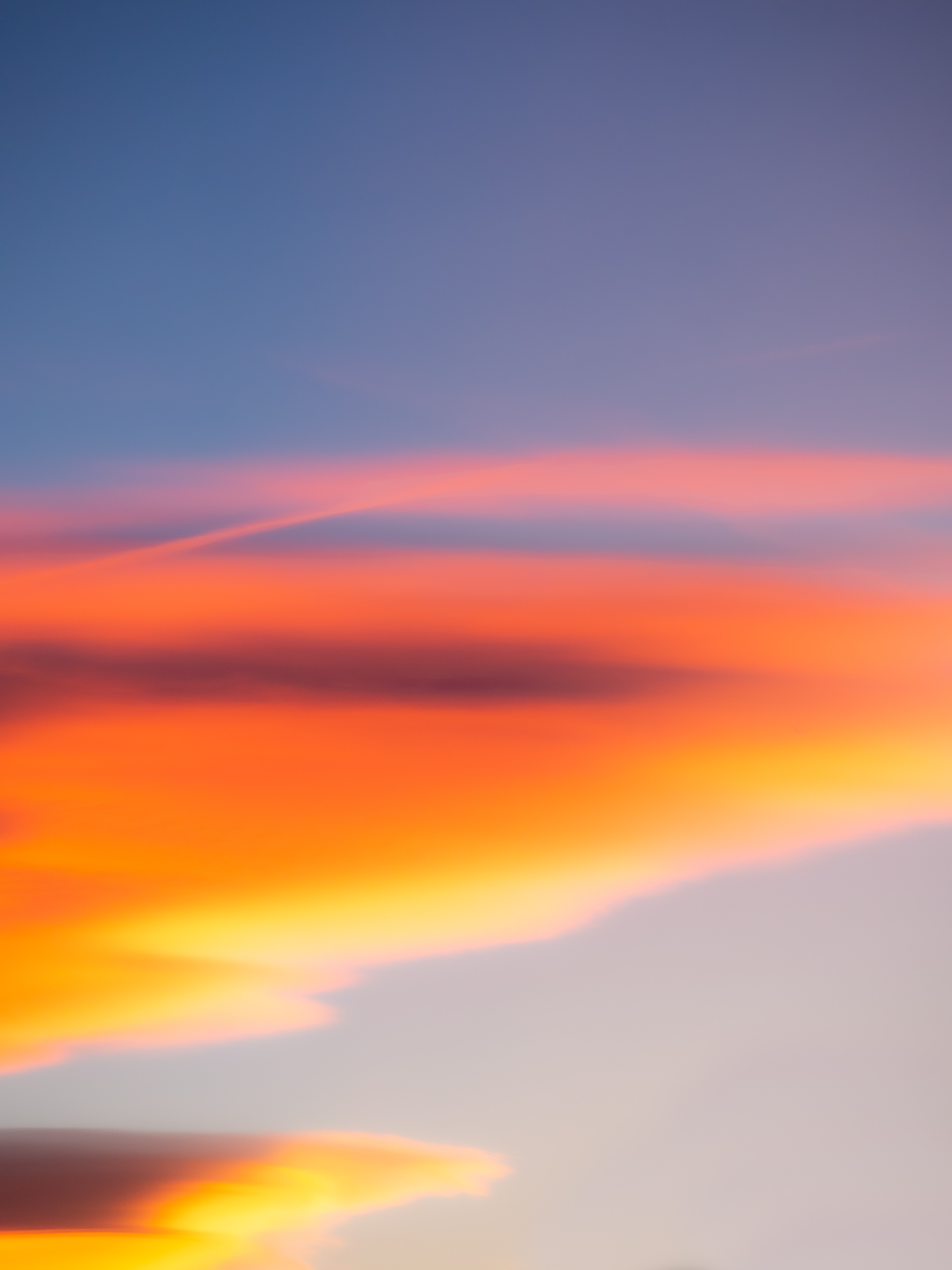 Beautiful sunset with blue sky and vibrant red, orange, and yellow clouds