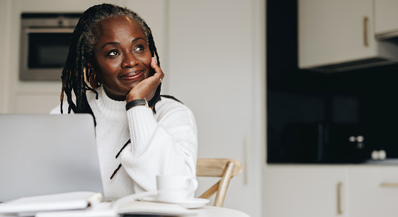 Image of a woman using a laptop and thinking