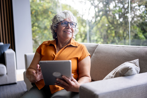 Image of a happy woman looking at a tablet