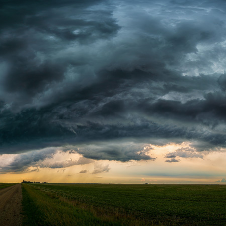 Storm clouds rolling in over a farm field