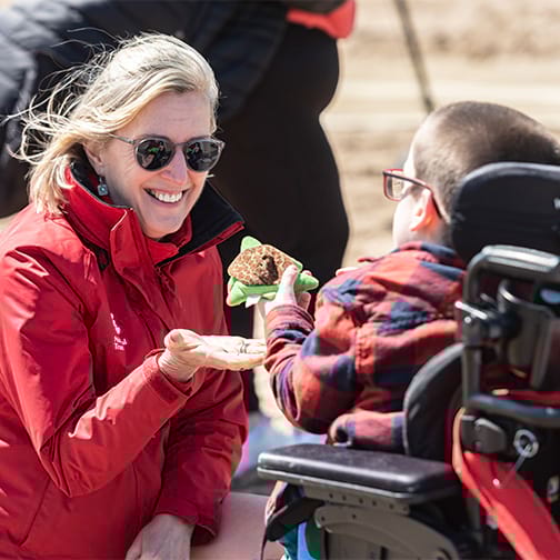 Director General chatting to person in a wheelchair on the beach