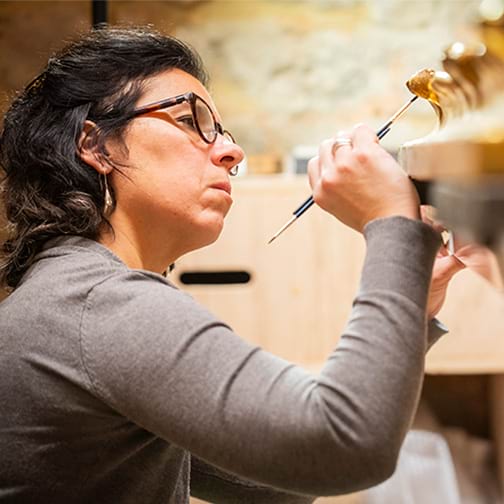 Person carrying out delicate conservation work on a picture frame
