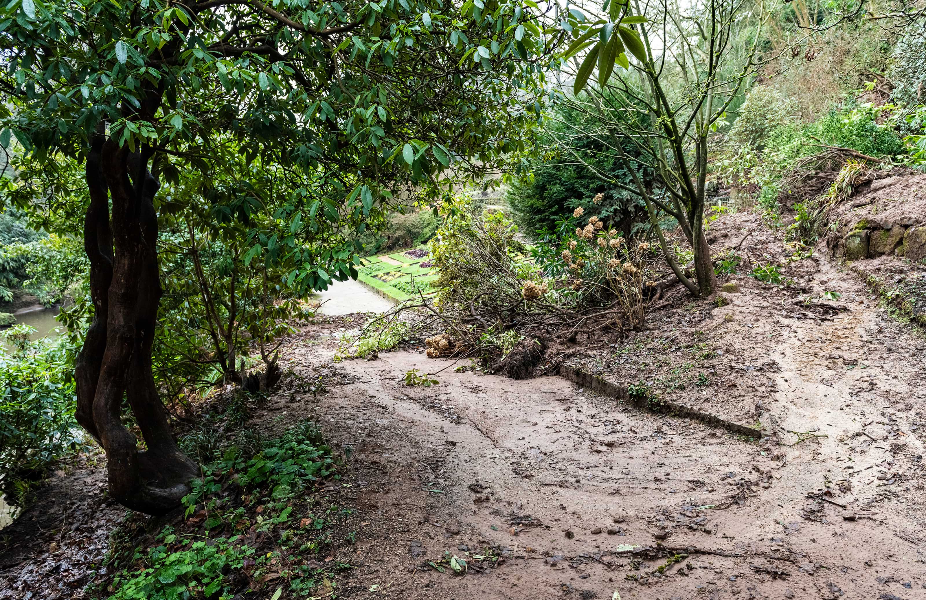 Path is shown covered In mud which has slipped down the bank making it very dangerous