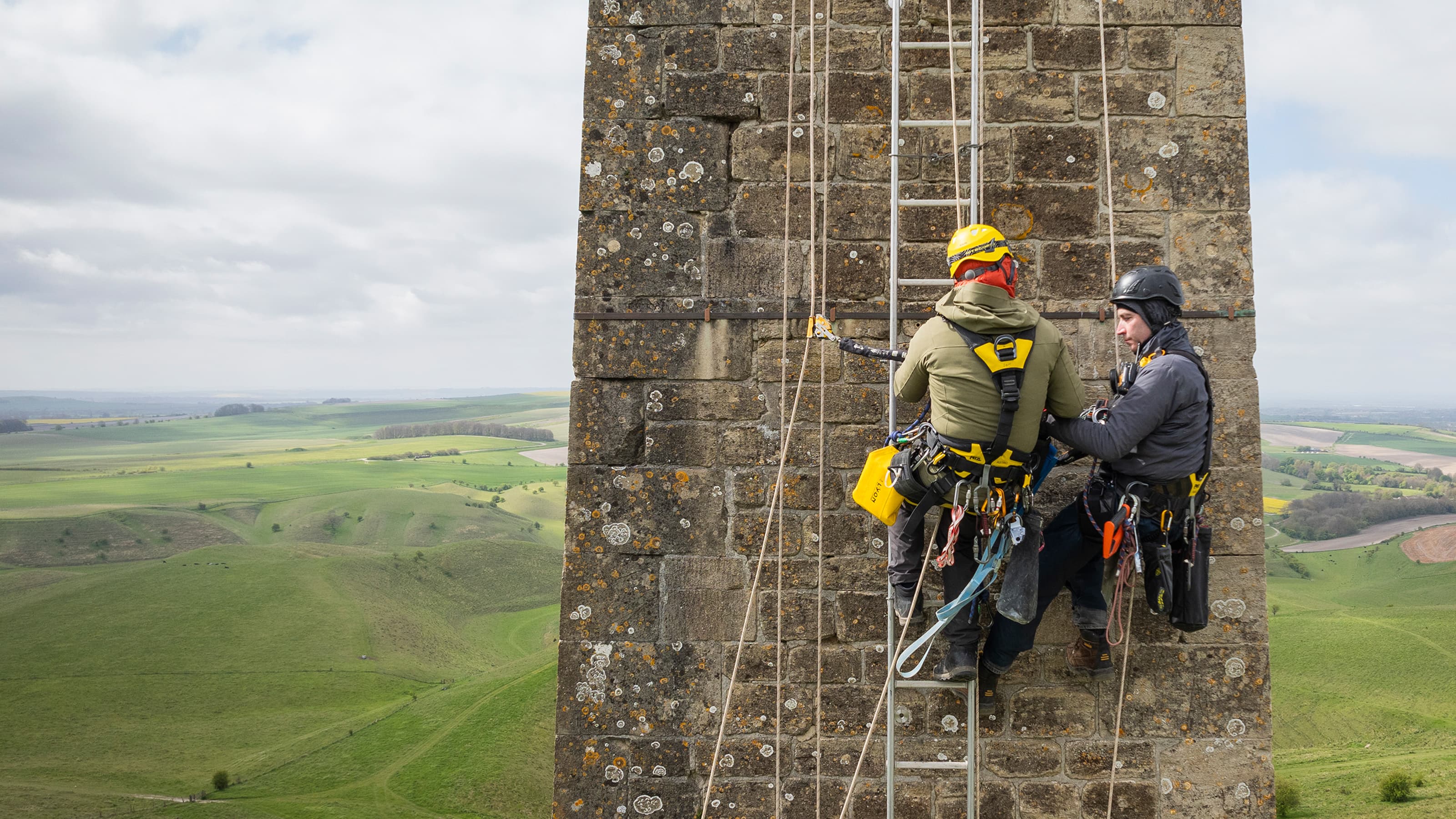 Workers high up on ropes assessing Lansdowne Monument at Calstone and Cherhill Downs, Wiltshire