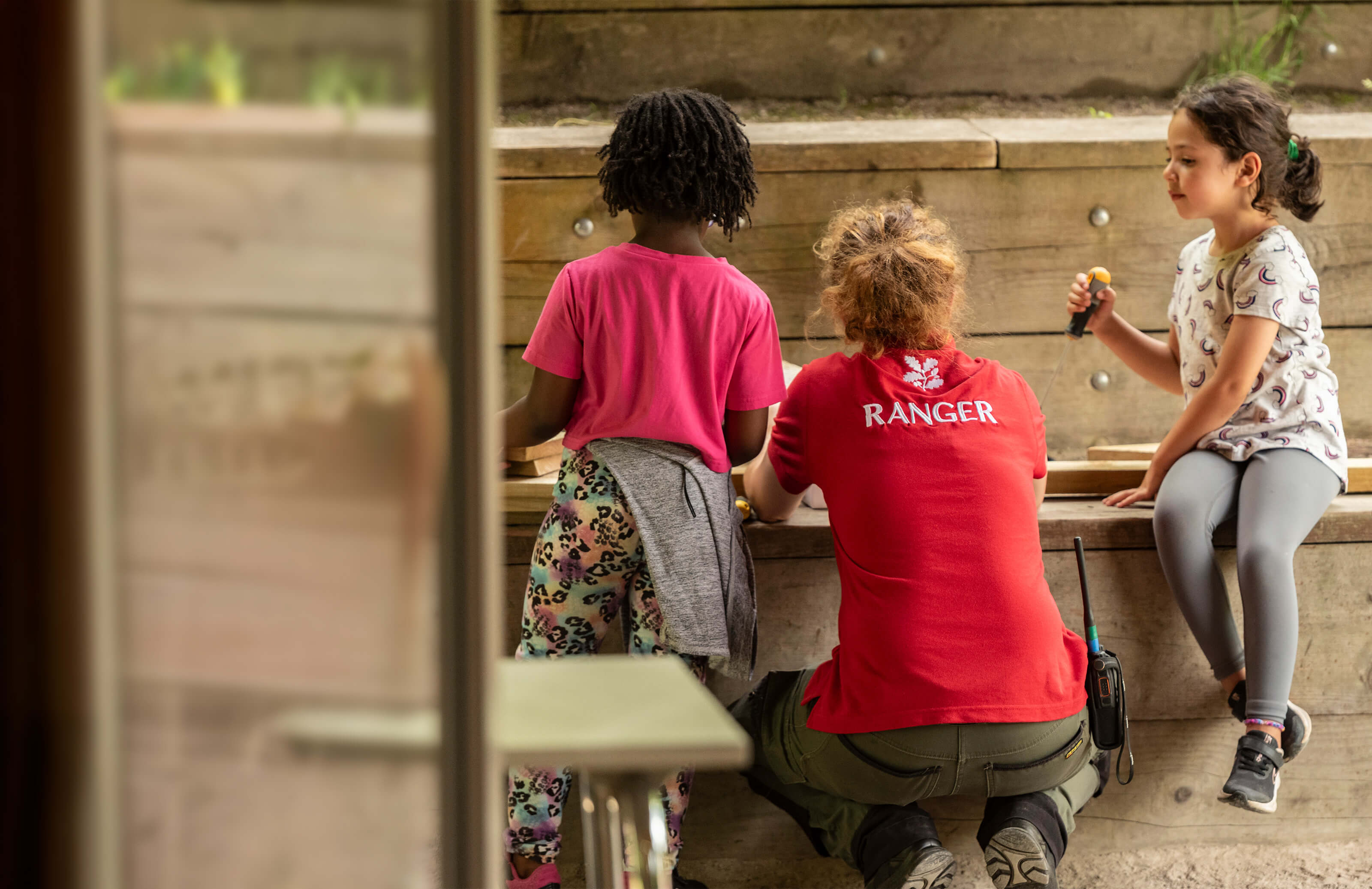 A National Trust representative helps two children with an activity 