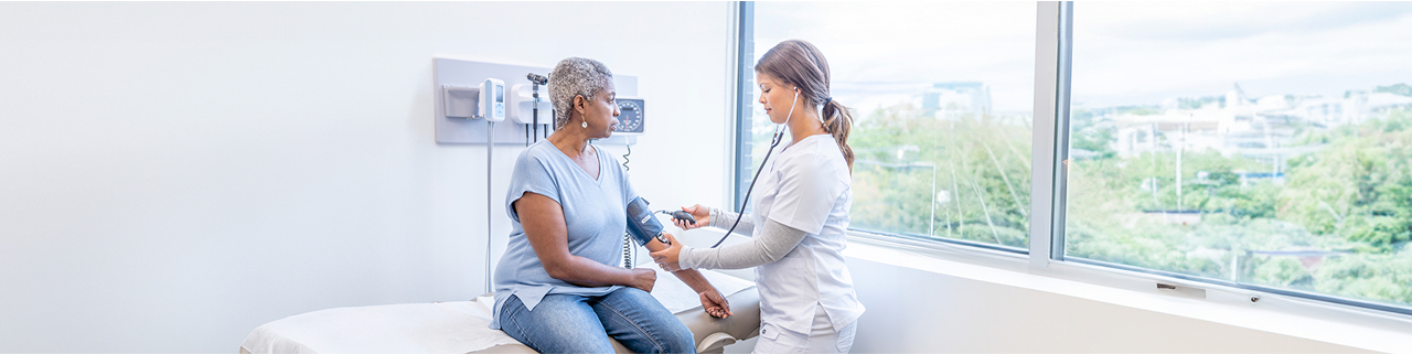 Doctor taking blood pressure of senior patient