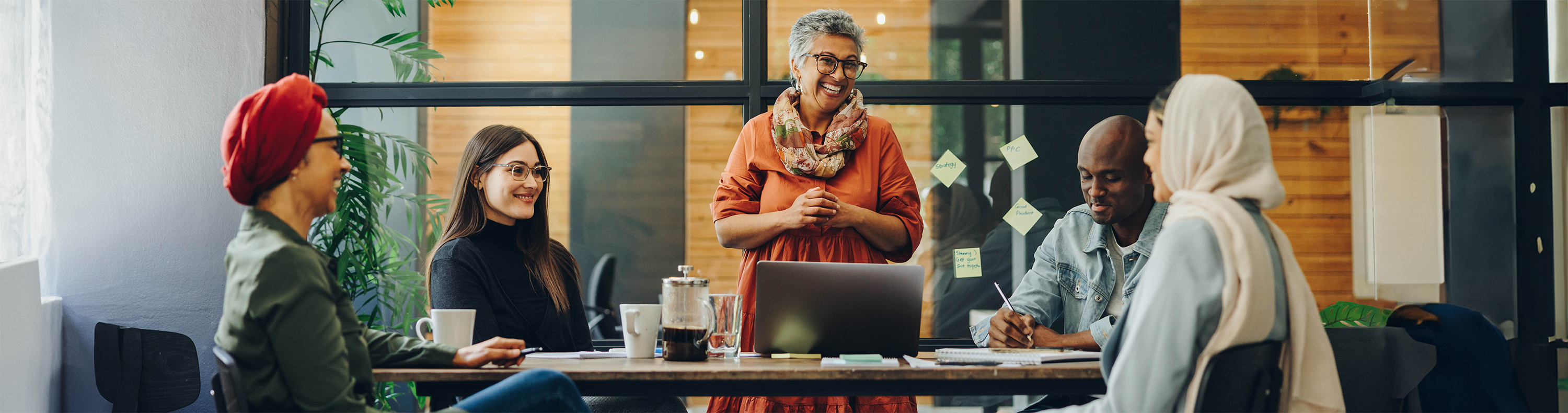 Employees smiling and talking around a conference table