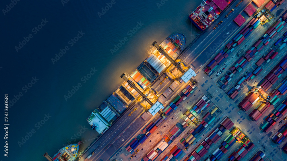 Young brunette woman and a senior lady using their devices while sharing a desk and keeping social distance