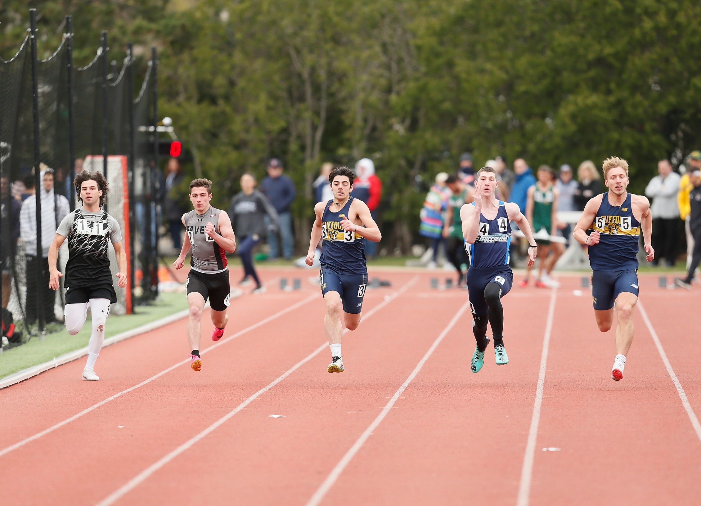 five male athletes running on a track in a race