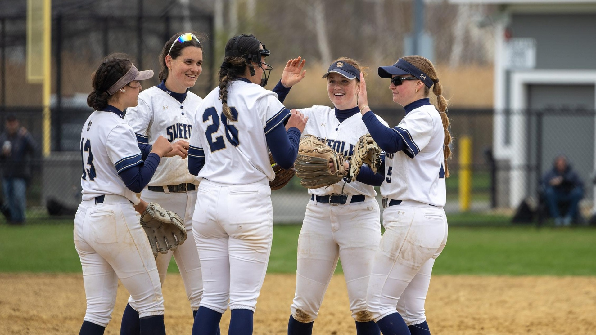 Suffolk Softball team going in for a high five mid-game