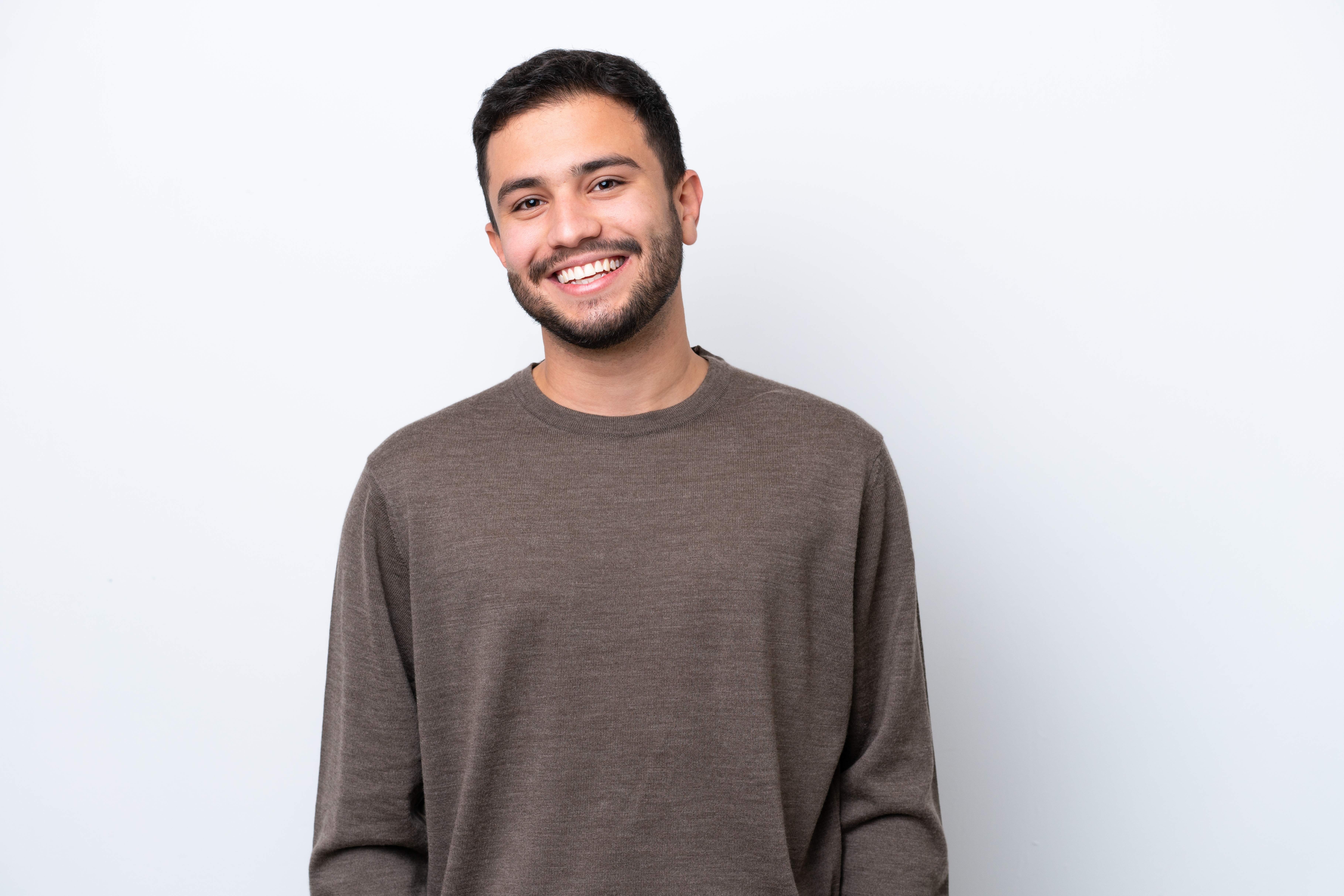 young man with short brown hair and beard smiling