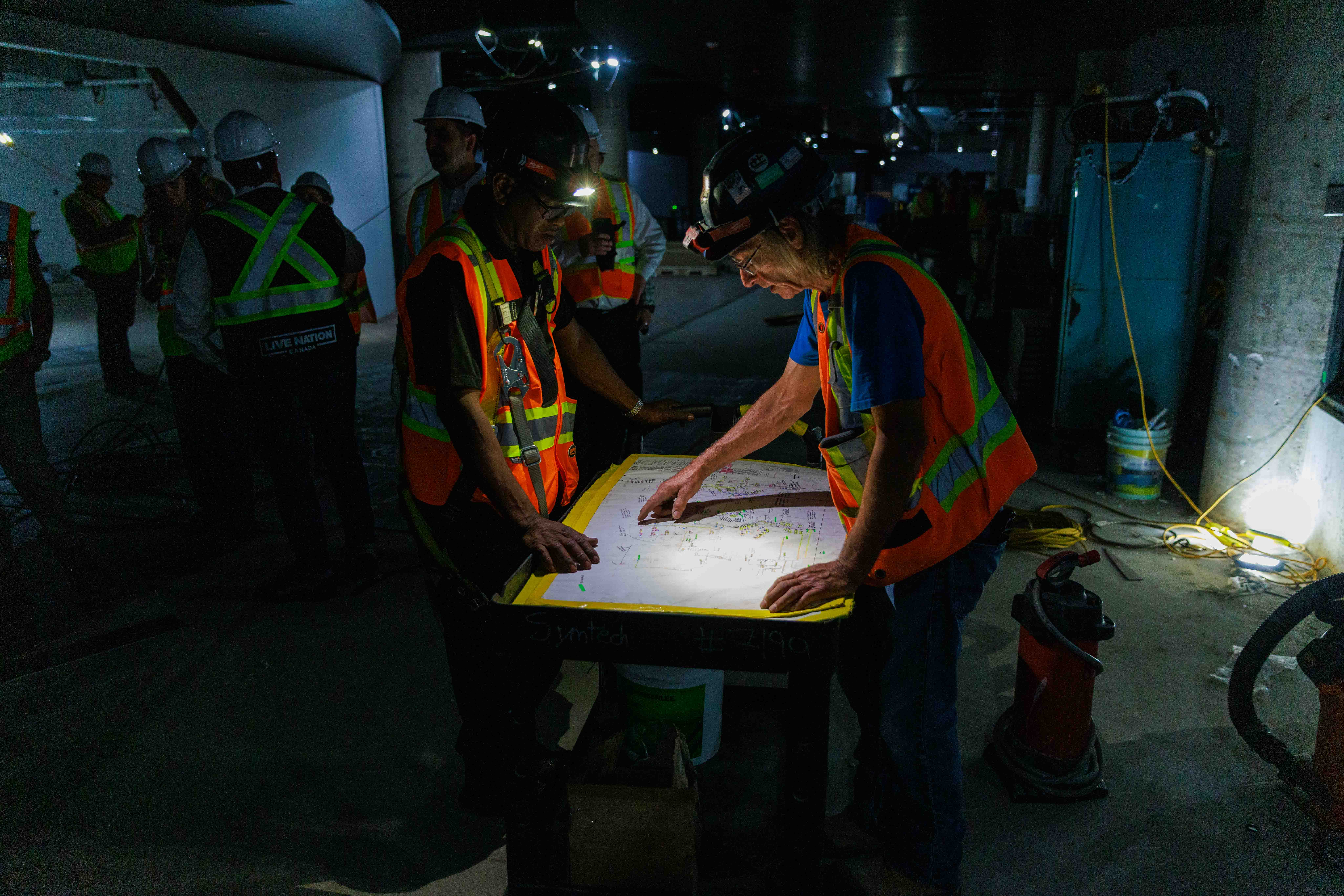 Photo d'ouvriers examinant des plans et des plans sur le chantier de construction du TD Coliseum.