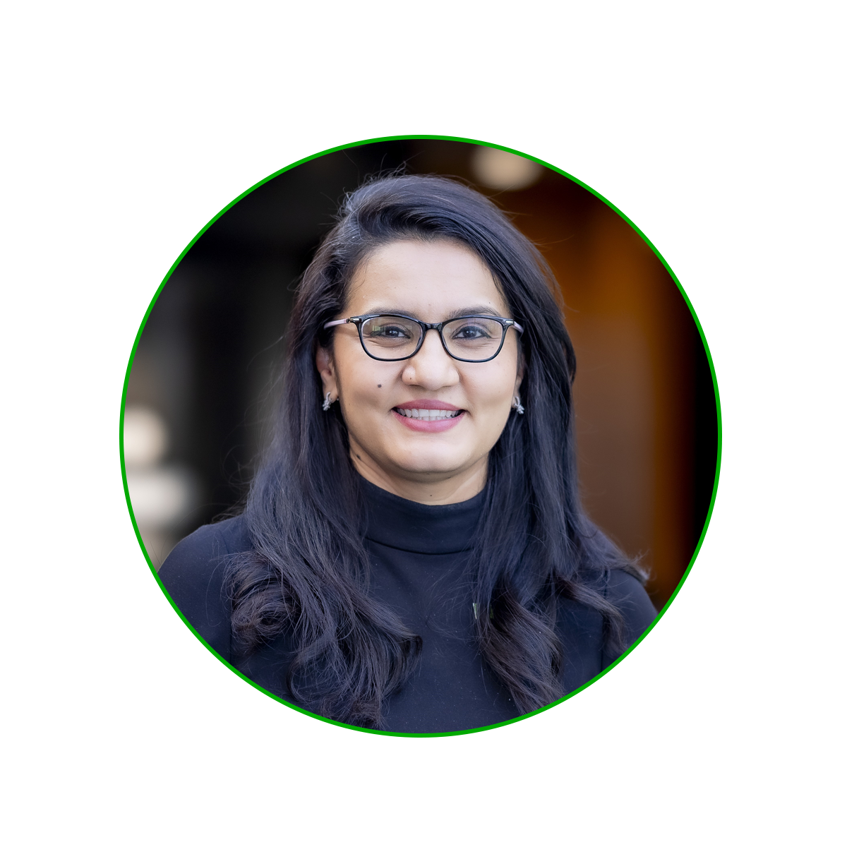 Headshot of Jo Jagadish: Woman with long, black hair, wearing a black long sleeve top with glasses 