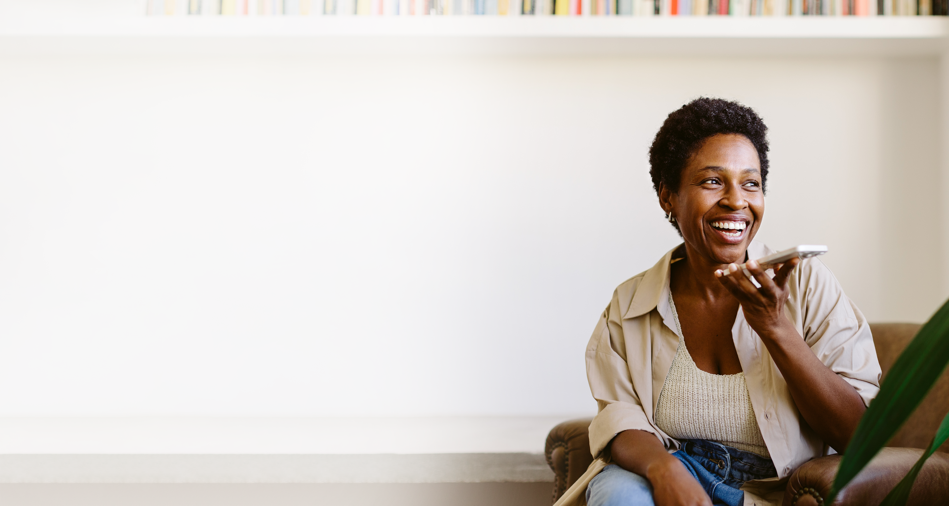 Photo of woman with black, short hair smiling while talking into a phone 