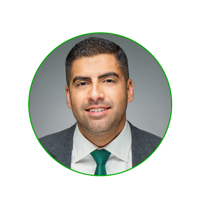 headshot of Sanj Rana: Tan man with dark, short hair, wearing a suit with a green tie