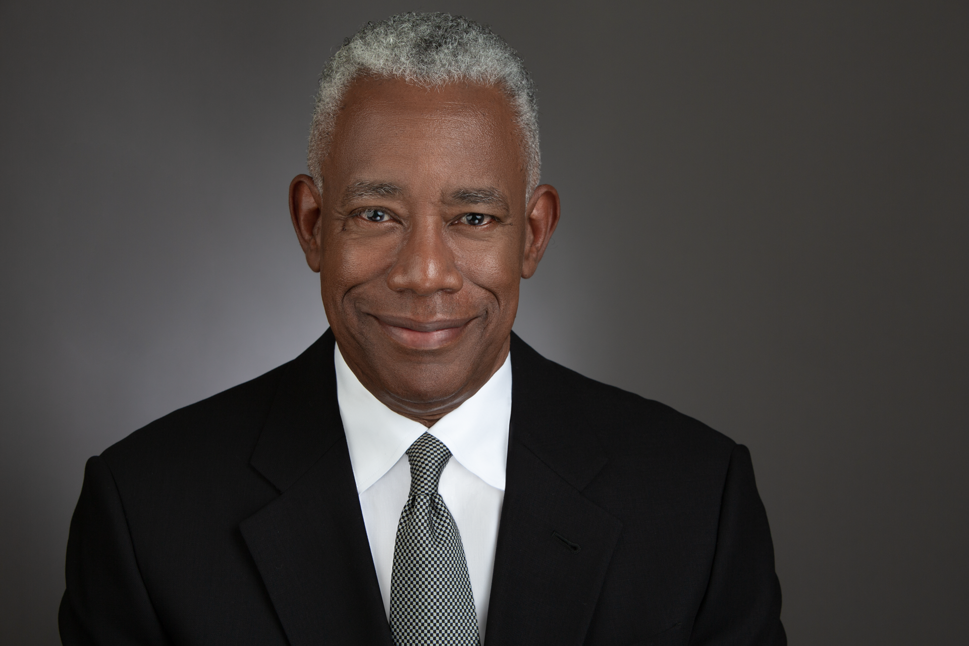 Joseph Simmons (African American man with gray hair, wearing a black suit)