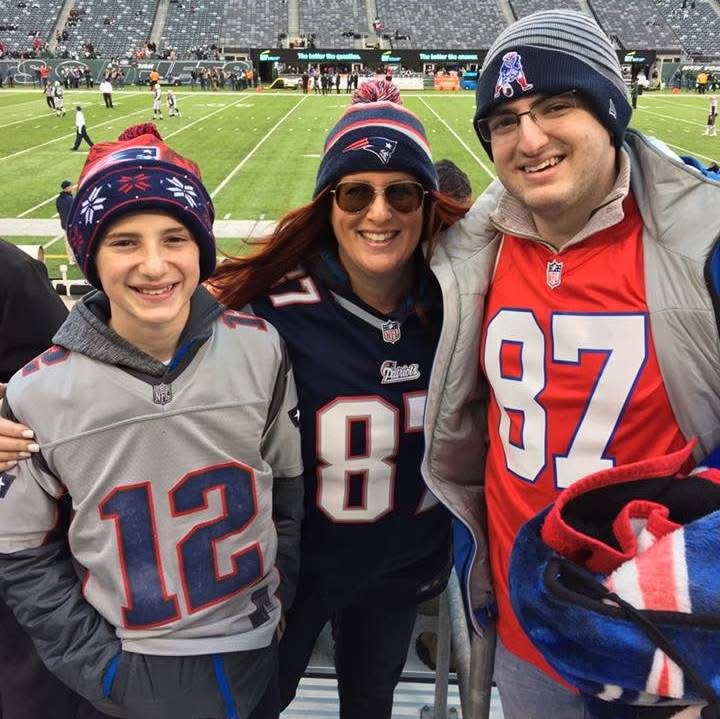 Family, young boy on left, woman in the middle, man on the right, at a Patriots Football game