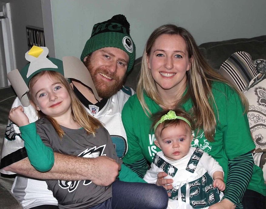 Family photo of two young girls and a man and a woman with Philadelphia Eagles gear on