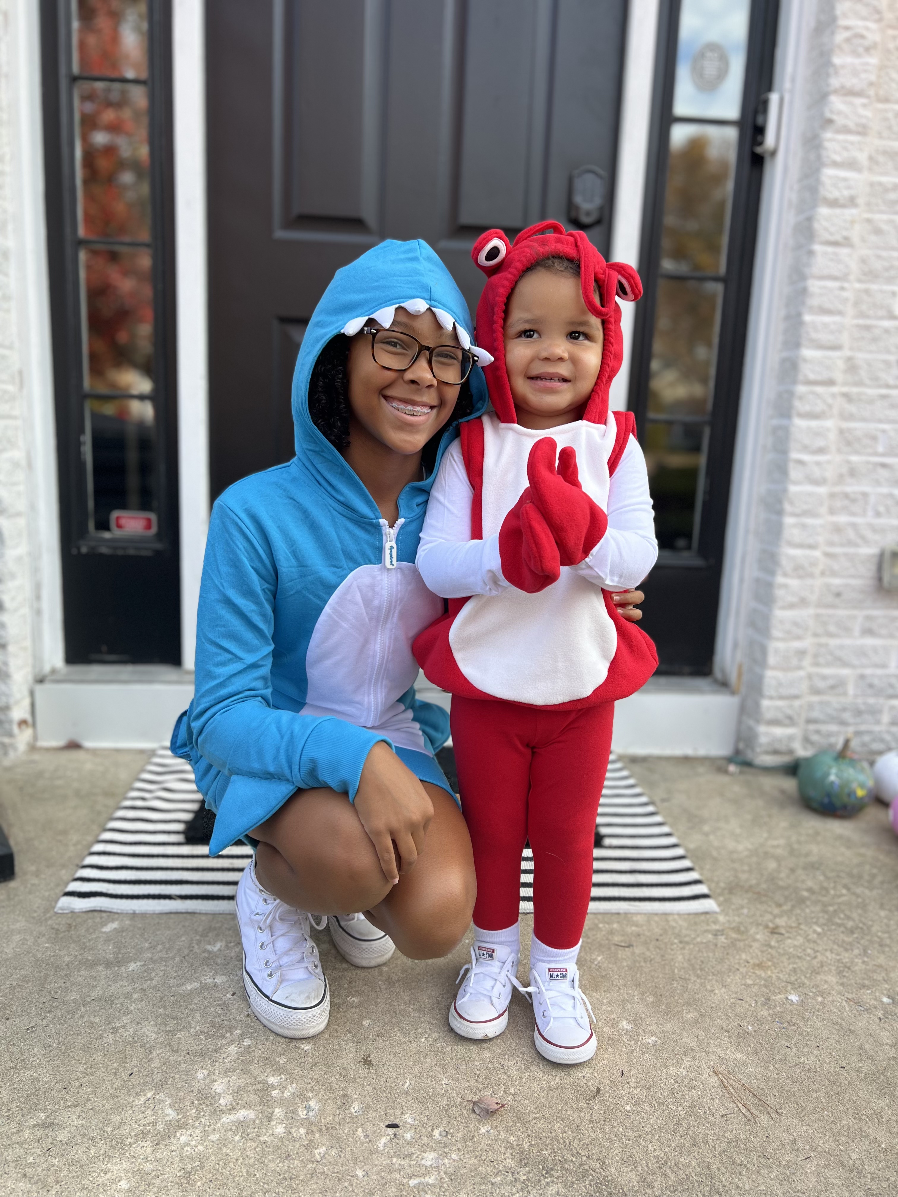 A young girl dressed as a shark next to a toddler dressed as a crab. 