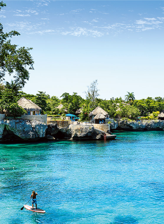 A person paddleboarding in Jamaica. 