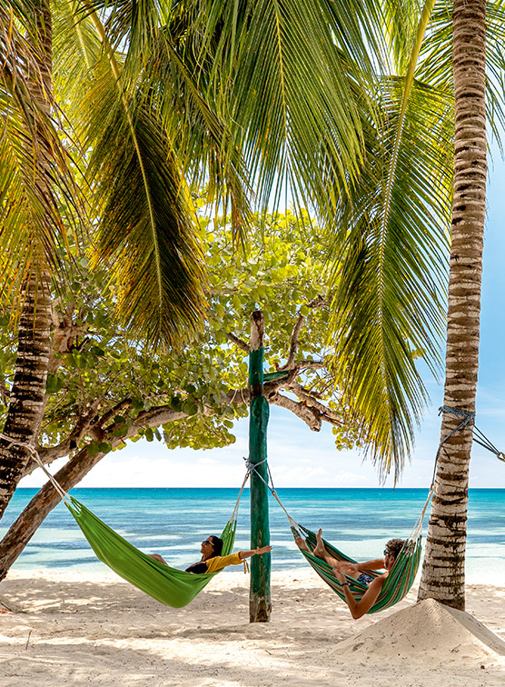 People hanging in hammocks on a beach in the Dominican Republic.