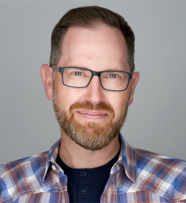 Headshot portrait of smiling young African American businessman in suit pose in own modern office. Profile picture of happy successful male boss or CEO in formalwear show confidence and leadership.