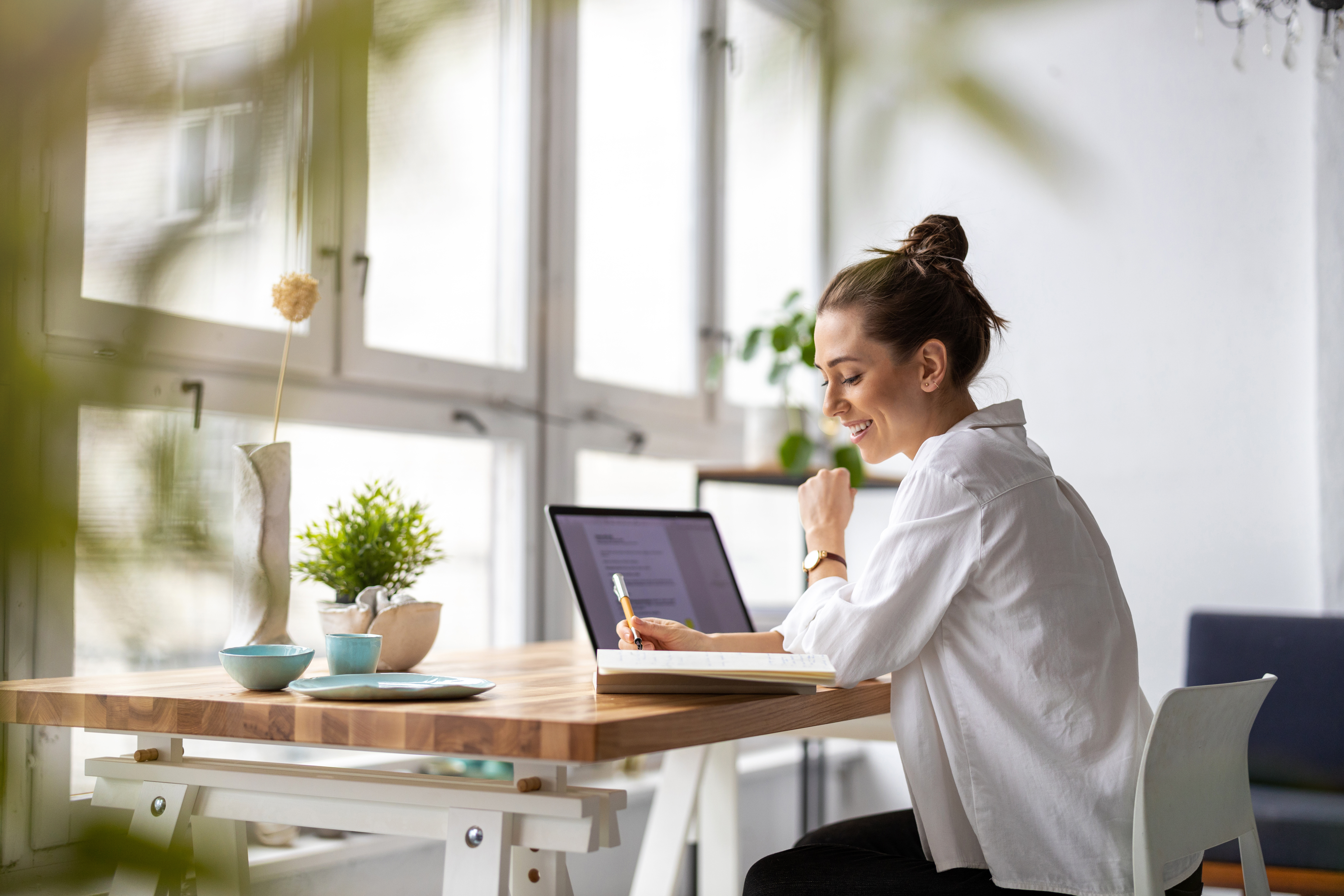 Clothing store owners having a discussion while preparing online orders for shipping. Two young women using a laptop together in a thrift store. Female entrepreneurs running an e-commerce small business.