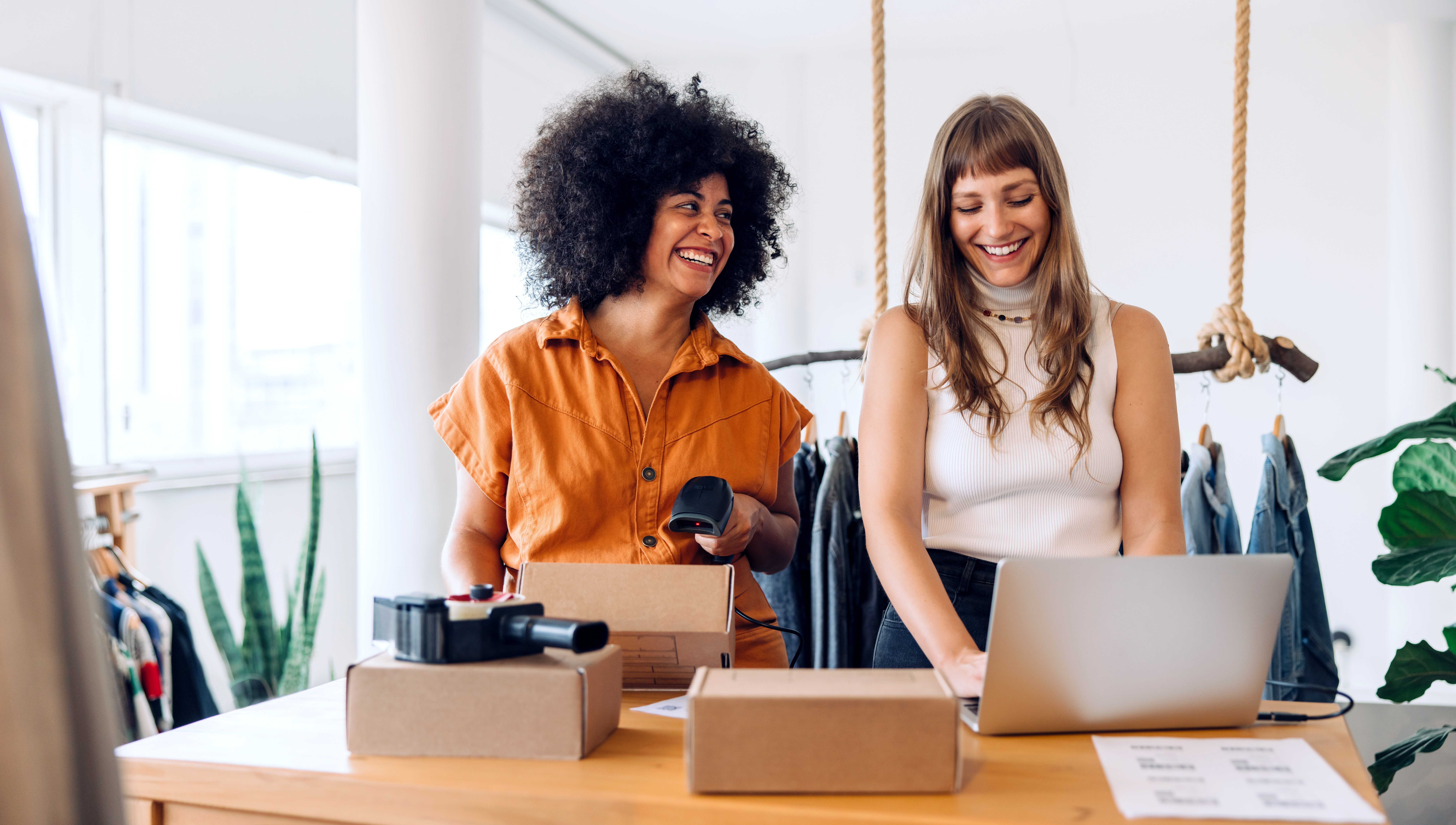 two women packaging cardboard boxes in their business